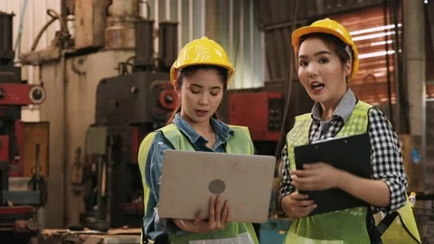 Two cute young female engineers using laptop to look at project plan Stock Footage 130191486