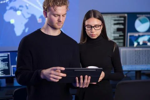 Two cybersecurity professionals analyzing data in a secure operations center Stock Photos