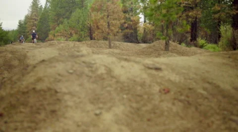Two cyclist ride over rough dirt terrain Stock Footage 59540289