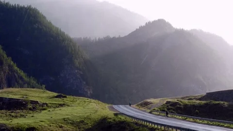 Two cyclists are driving along mountain highway. Beautiful mountains in summer Stock-Footage 163658140