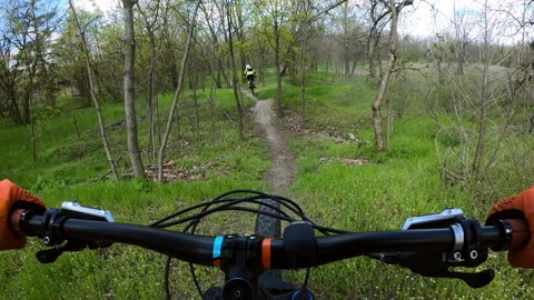 Two cyclists are riding on a difficult forest trail on mountain bikes. MTB... Stock Footage 274845871