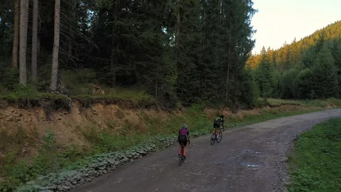 Two cyclists in beautiful mountain countryside. Aerial 4k shot Stock Footage 114428587