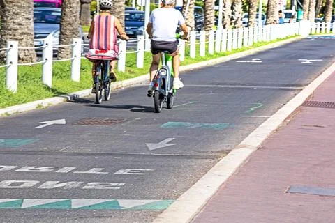 Two cyclists on a bike path with arrows on a hot day Stock Photos