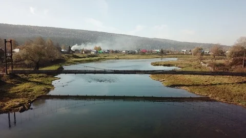 Two cyclists cross the river on a suspension bridge Video stock 81000000