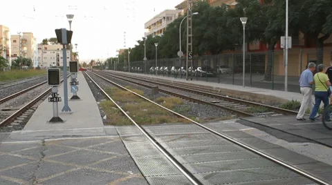 Two cyclists crossing the rails at a grade crossing Stock Footage 8582929