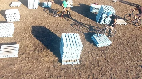 Two cyclists doing jump MTB tricks bicycle HD aerial video. Mountain bike trial Stock Footage 67861637