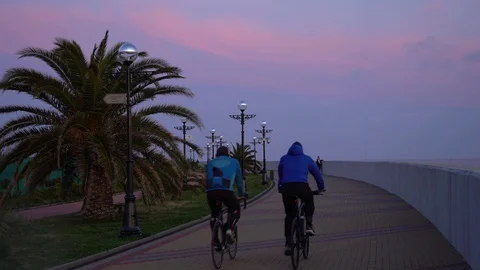 Two cyclists on the promenade in the evening Video stock 129111832