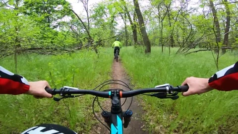 Two cyclists ride a forest trail on a cloudy day. Mountain bike. Stock Footage 138007385