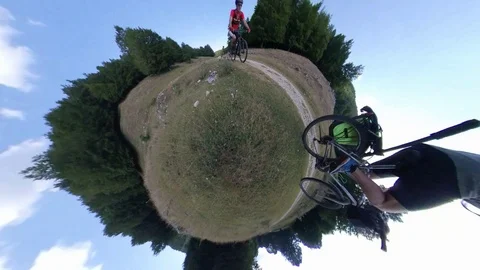 Two Cyclists ride on a mountain path at sunny morning, VR360 effect Stock Footage 113053966