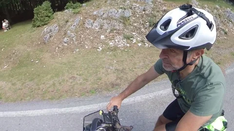 Two Cyclists ride on a mountain road trough the forest at morning, VR360 effect Stock Footage 113054655