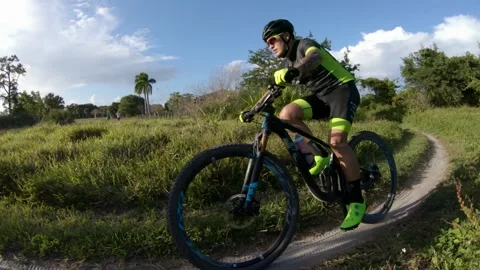 Two Cyclists Ride Right-to-Left Into Afternoon Sun Stock Footage 200797763