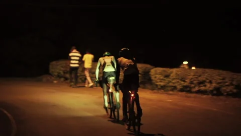 Two cyclists ride together in the middle of the night Stock Footage 138631068