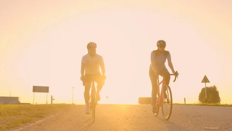 Two cyclists ride together in mountains. Softly focused hand held shot of two Stock Footage 115076402