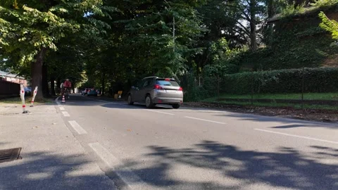 Two cyclists ride towards Dervio on Lake Como Stock Footage 318313666