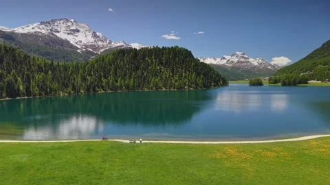 Two cyclists riding along the shore of Lake Champfer near St Moritz Stock Footage 341748708