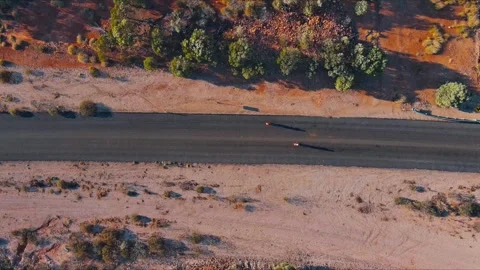 Two cyclists riding on the outback road in Queensland Australia Stock Footage 318509697