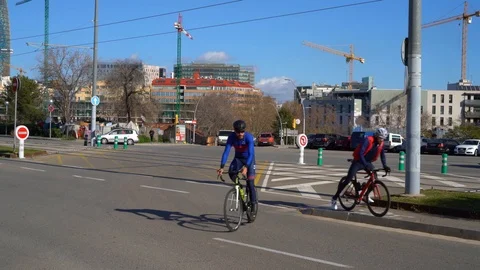 Two cyclists in tracksuits rode in opposite directions in center of Barcelona. Видео 123249977