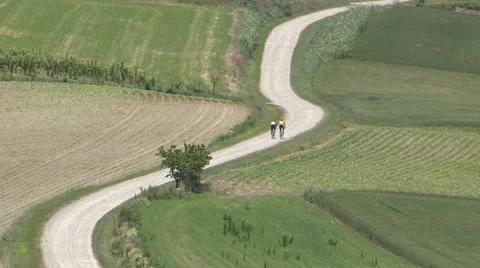 Two cyclists traveling an unpaved road Stock Footage 59679242