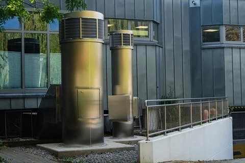 Two cylindrical vent pipe structures near a building in an urban area Fotos Stock
