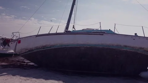 Two Damaged Sailboat leaning on the after a storm in Gulfport, Florida. Looking  Stock Footage 260992690