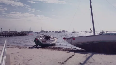 Two Damaged Sailboat leaning on the after a storm in Gulfport, Florida. Looking  Stock Footage 260992760