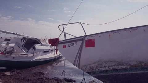 Two Damaged Sailboat leaning on the after a storm in Gulfport, Florida. Looking  Stock Footage 260993718