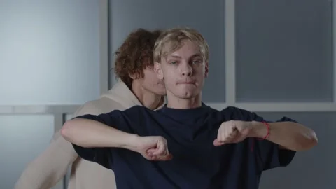 Two dance performers making arm moves in studio. Twin boys dancing together Stock Footage 231674517