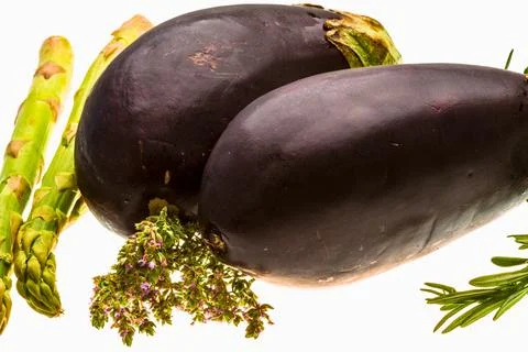 Two dark purple root vegetables with asparagus and herbs Stock Photos
