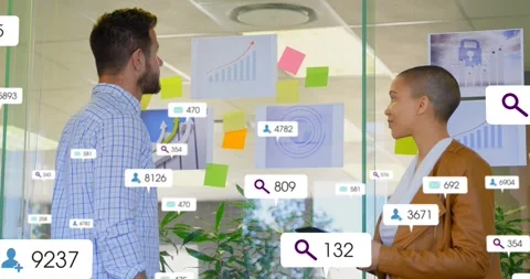 Two data analysts sharing insights starting floating data icons on glass charts Stock Footage 317265386