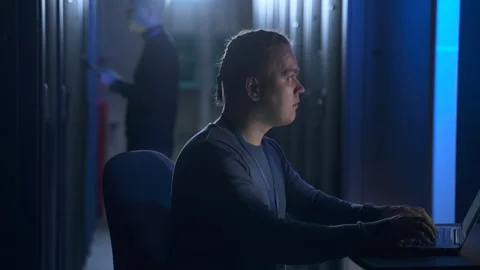 Two data engineers working with devices and checking equipment racks in modern Stock Footage 163816739