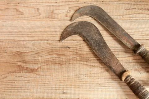 Two dated and used billhooks on wooden background Stock-Fotos
