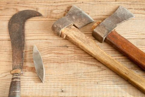 Two dated and used cleavers and billhook on wooden background Stock Photos