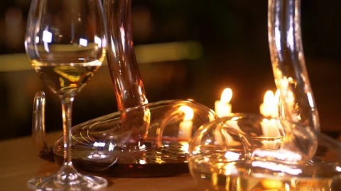 Two decanters  are filled with red and white wine by candlelight. Stock Footage 125057428
