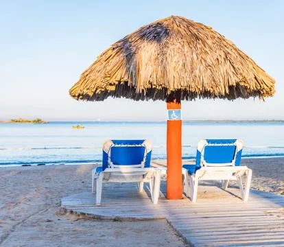 Two deck chairs under an umbrella Fotos de archivo