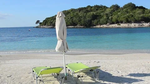 Two deckchair and parasol on sandy beach. Exotic beach at summer Stock Footage 142310518