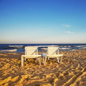 Two deckchairs on the sandy beach Stock Photos