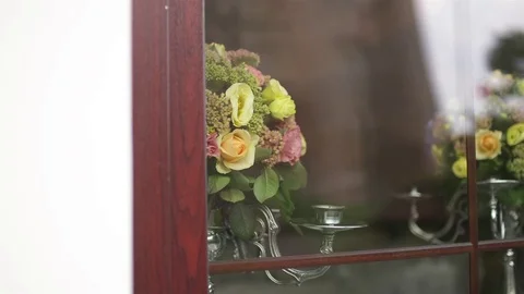 Two Decorated Silver Candlesticks with Flowers Through the Window Glass Stock Footage 69817988