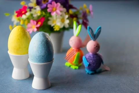 Two decorative eggs in white coasters, two decorative bunnies and bright flow Stockfoto's
