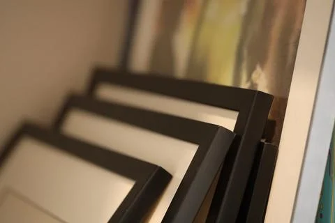 Two decorative picture frames sit atop a wall, ready for hanging Stock Photos