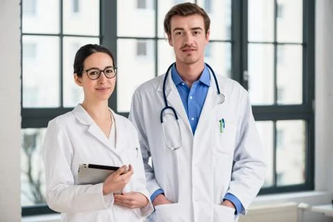 Two dedicated doctors smiling at camera Stock Photos
