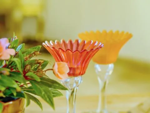 Two delicate glass candlesticks in delicate colors with flowers to the side, Stock Photos