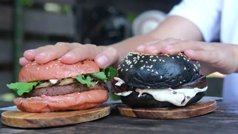 Two delicious burgers with different colored rye flour buns and black buns. A Stock Footage 182760481