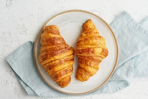 Two delicious croissants on plate and hot drink in mug. Morning French breakfast Stock Photos