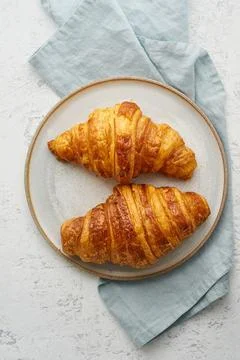 Two delicious croissants on plate and hot drink in mug. Morning French breakfast Stock Photos