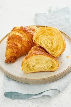 Two delicious croissants on plate and hot drink in mug. Morning French breakfast Stock Photos