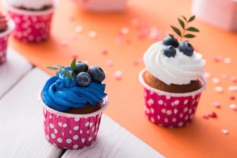 Two delicious cupcakes on a table Photos