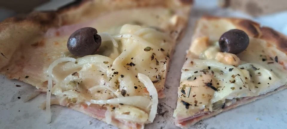 Two delicious slices of thin crust pizza topped with black olives Stock Photos