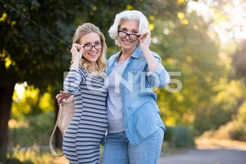 Two delighted pretty women smiling and hugging Stock Photos