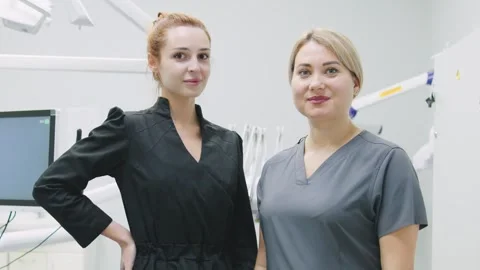 Two dental professionals stand together in a modern clinic during a patient Stock Footage 329318706