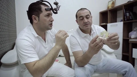 Two dentists having a professional discussion with teeth model Stock Footage 71396914